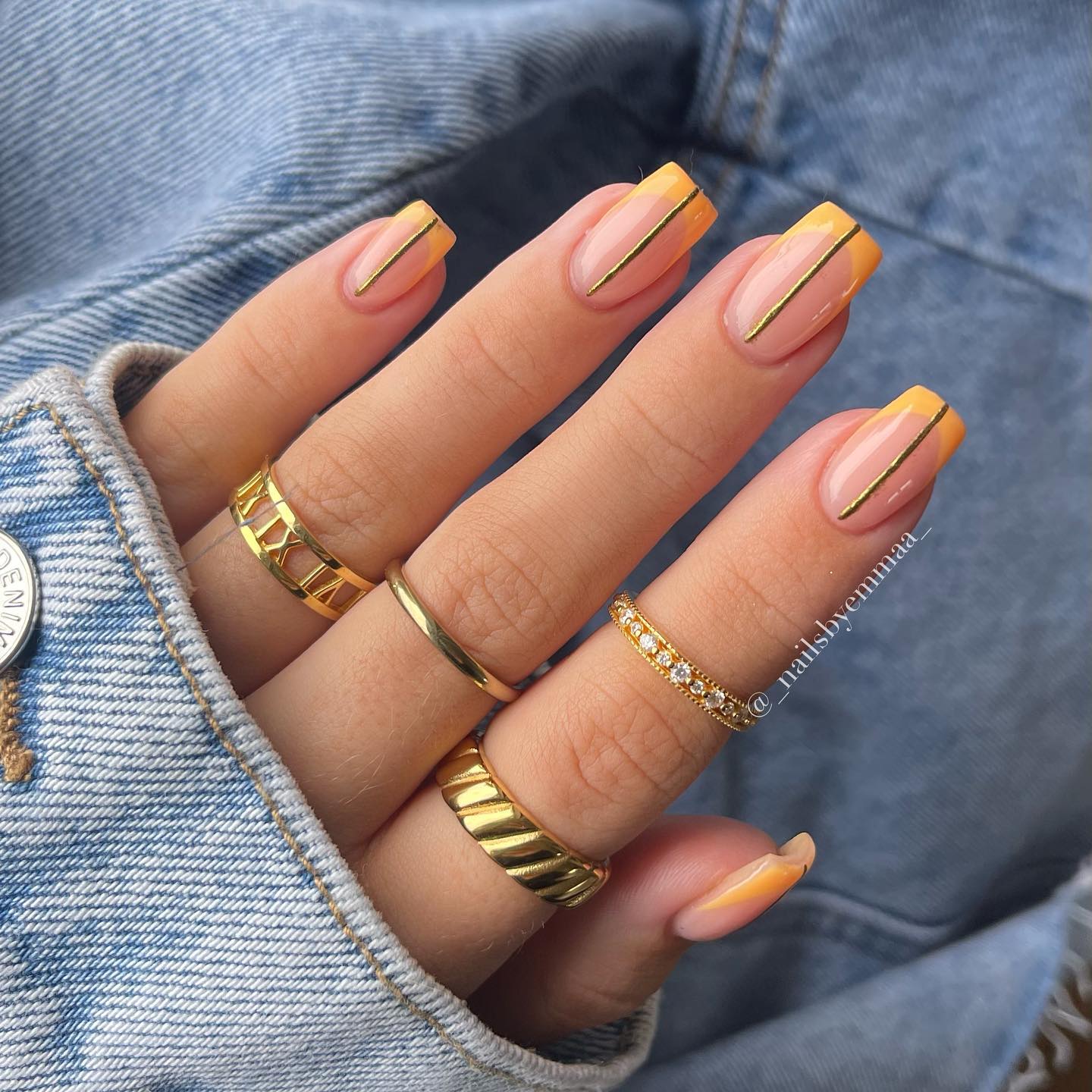 Orange French Tip Nails with vertical straight lines in the nail center