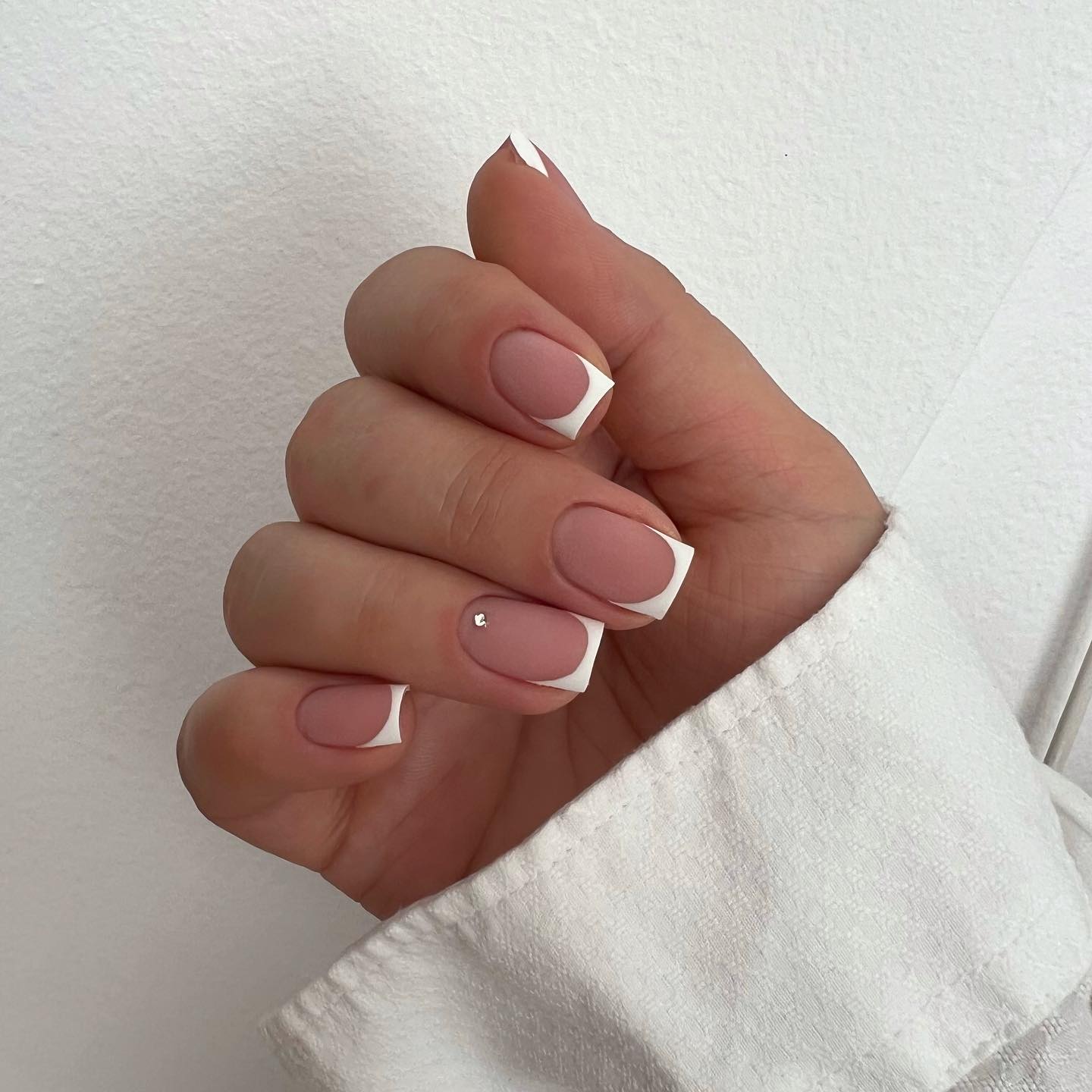Short White French Tip Nails with small diamond on fingernail