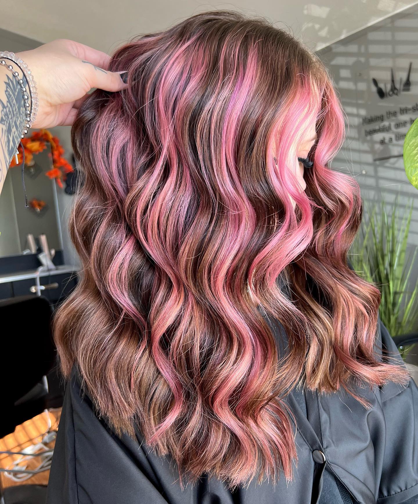 Nahaufnahmefoto von rosa Highlights auf natürlichem braunem Haar