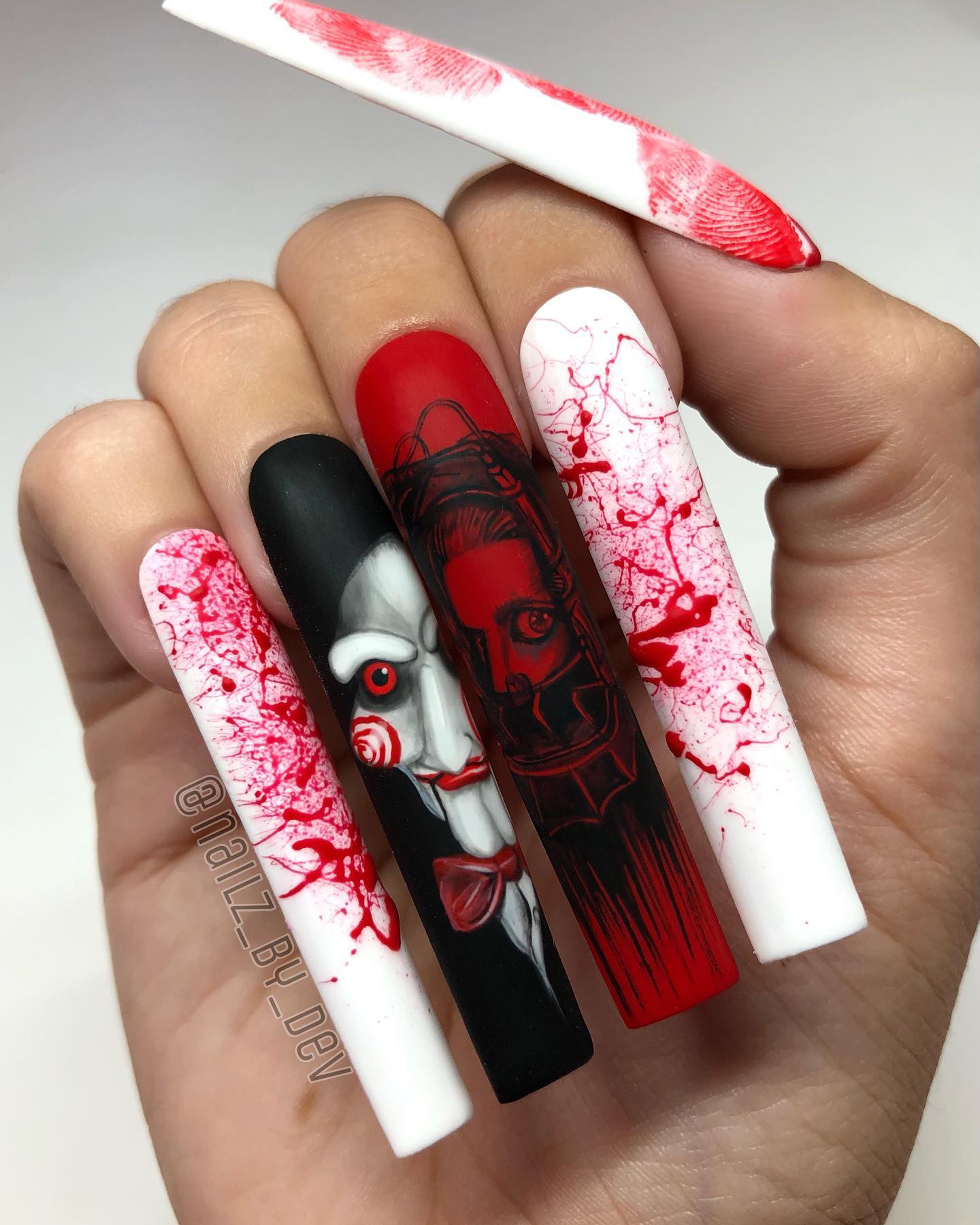 One more photo of short natural and long fake Halloween nails with scary faces on it