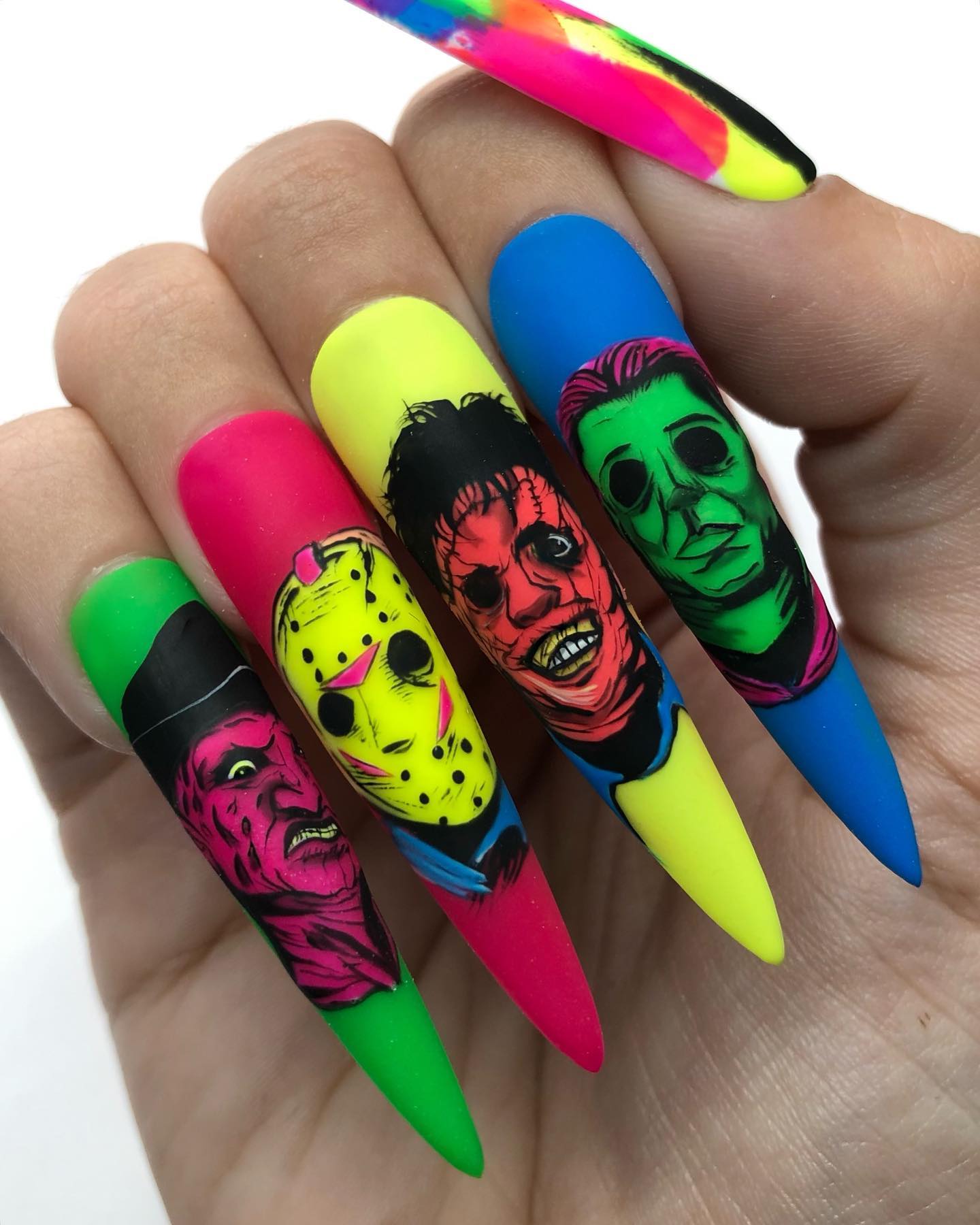 Another example of short natural and long fake Halloween nails with scary faces on it