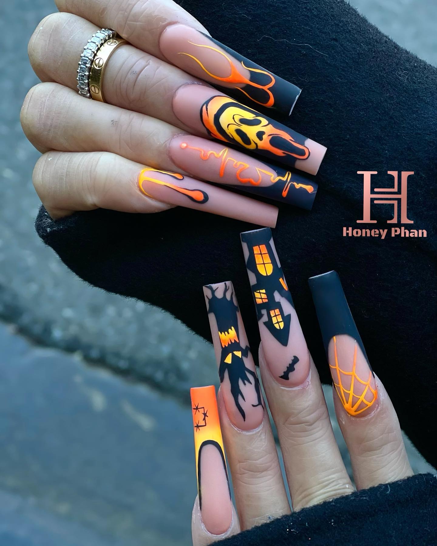 Kolejny przykład długich wciskanych paznokci pomalowanych w Halloweenowe opowieści w połączeniu czerni i pomarańczy