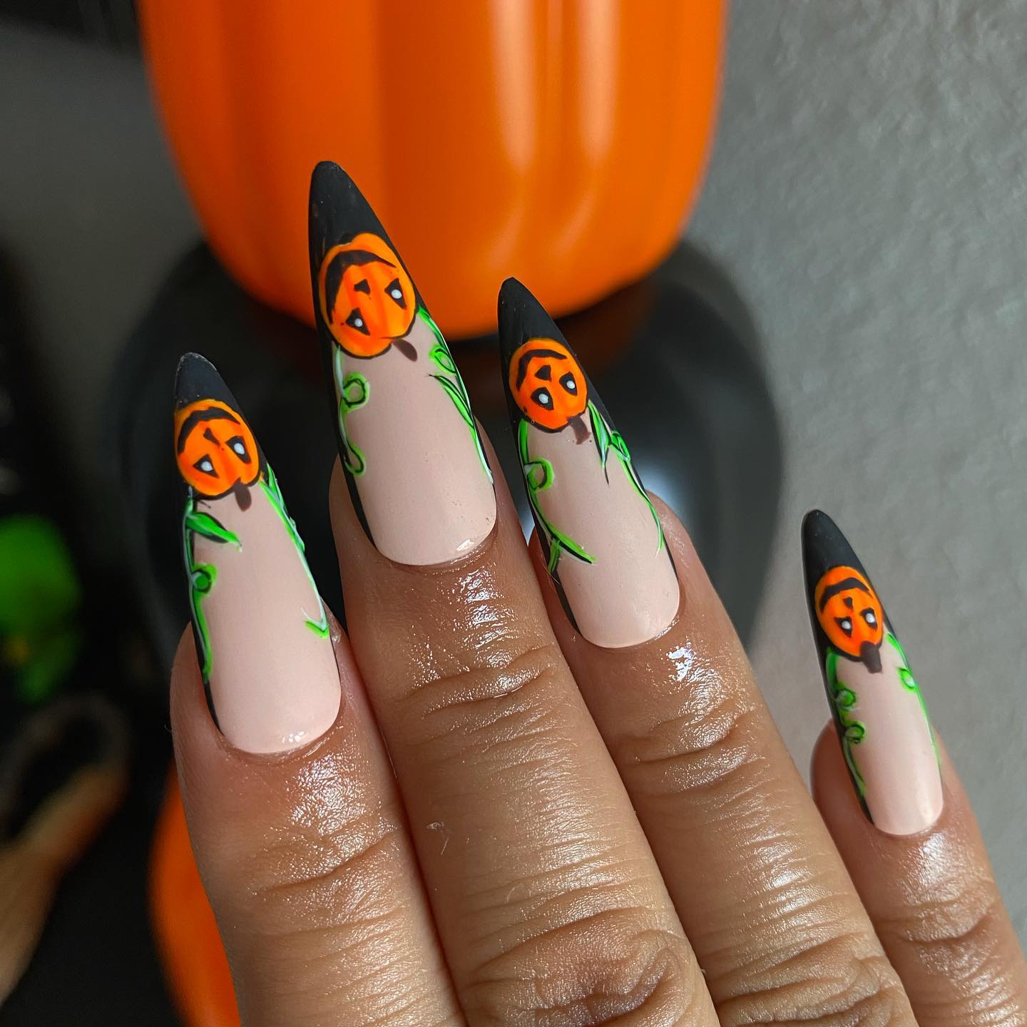 Kolejny przykład Halloweenowych paznokci migdałowych z malunkami w kształcie pomarańczowych dyń