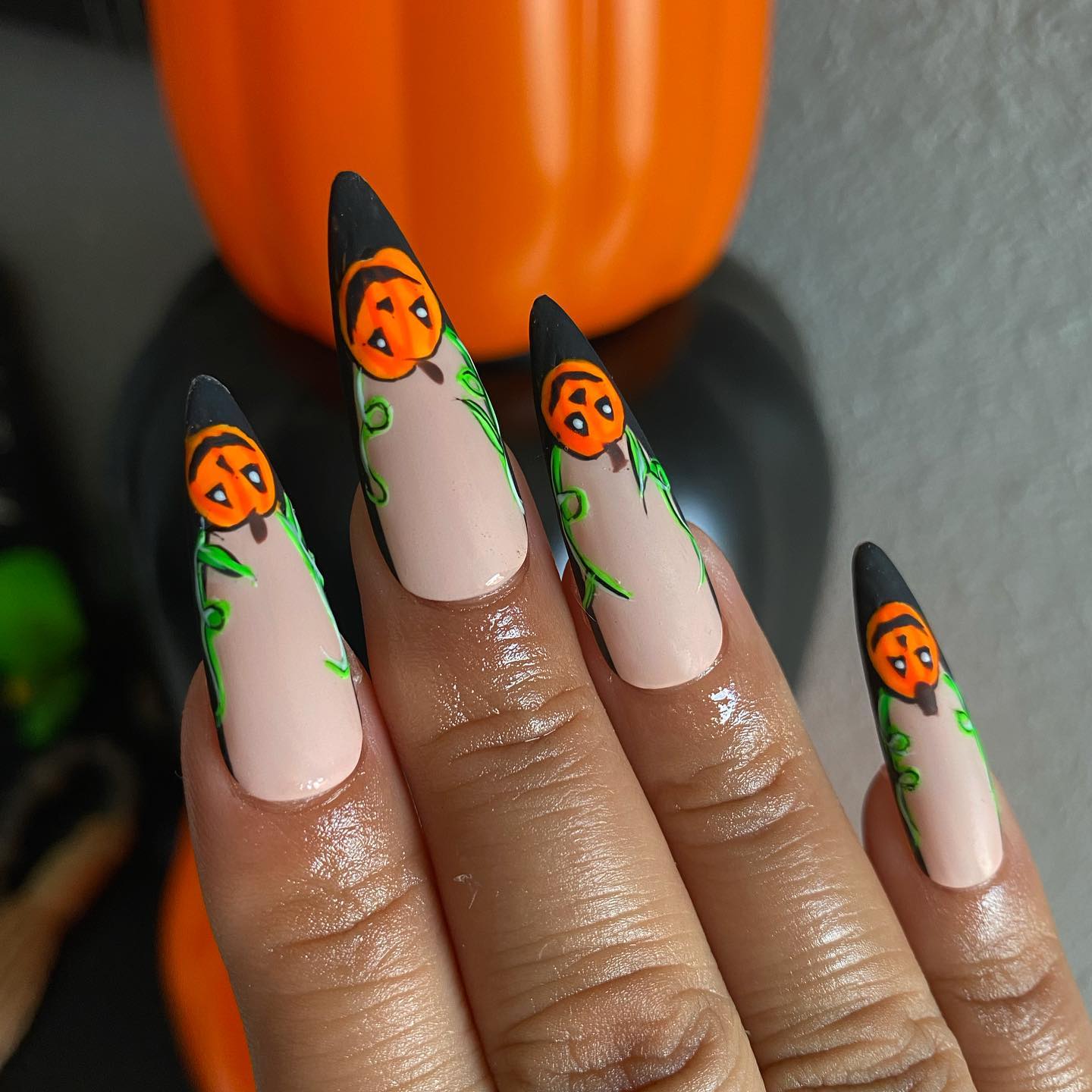 Another example of Halloween almond nails with paintings in form of orange pumpkins