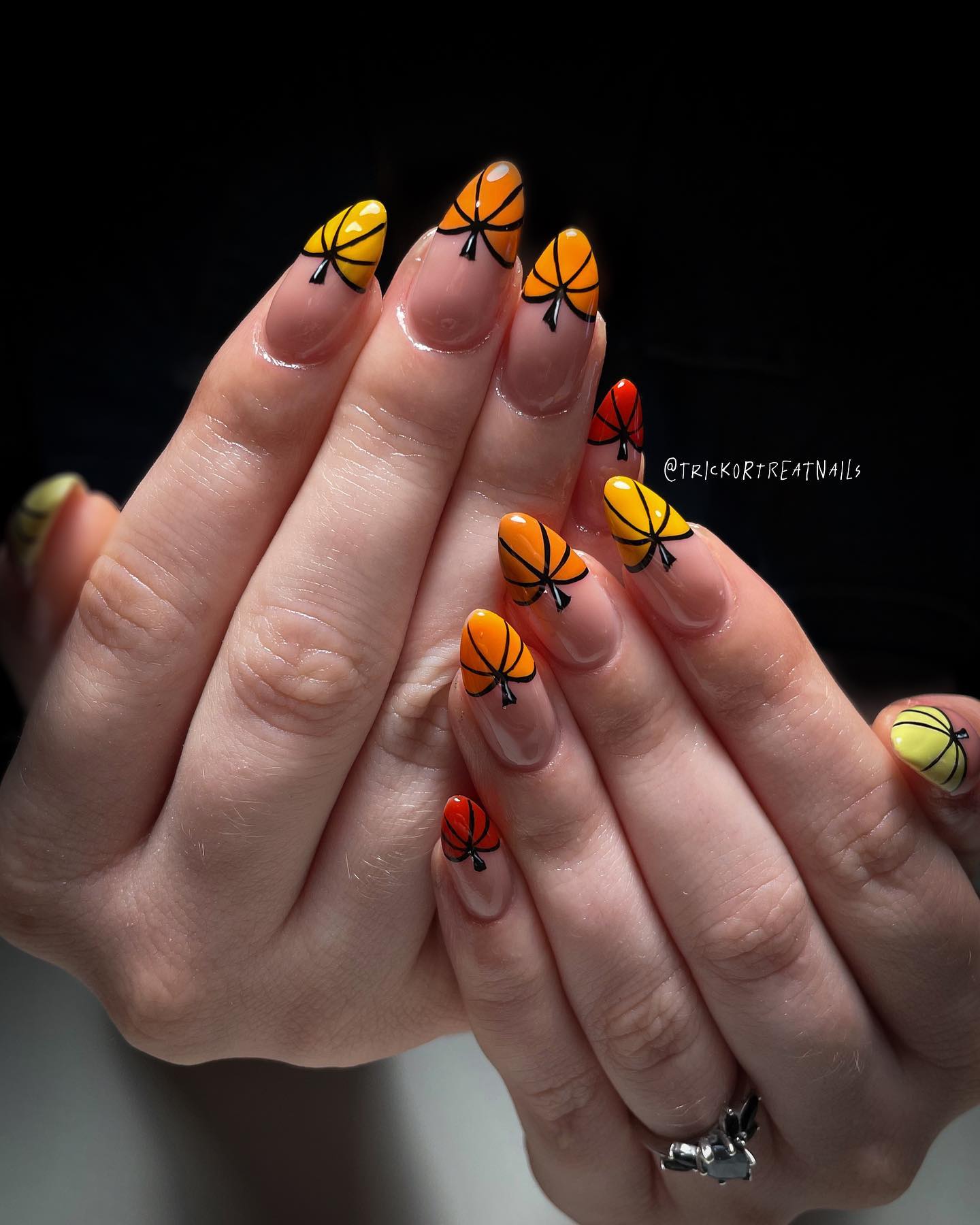 Jeszcze jedno zdjęcie Halloweenowych paznokci migdałowych z malunkami w kształcie pomarańczowych dyń