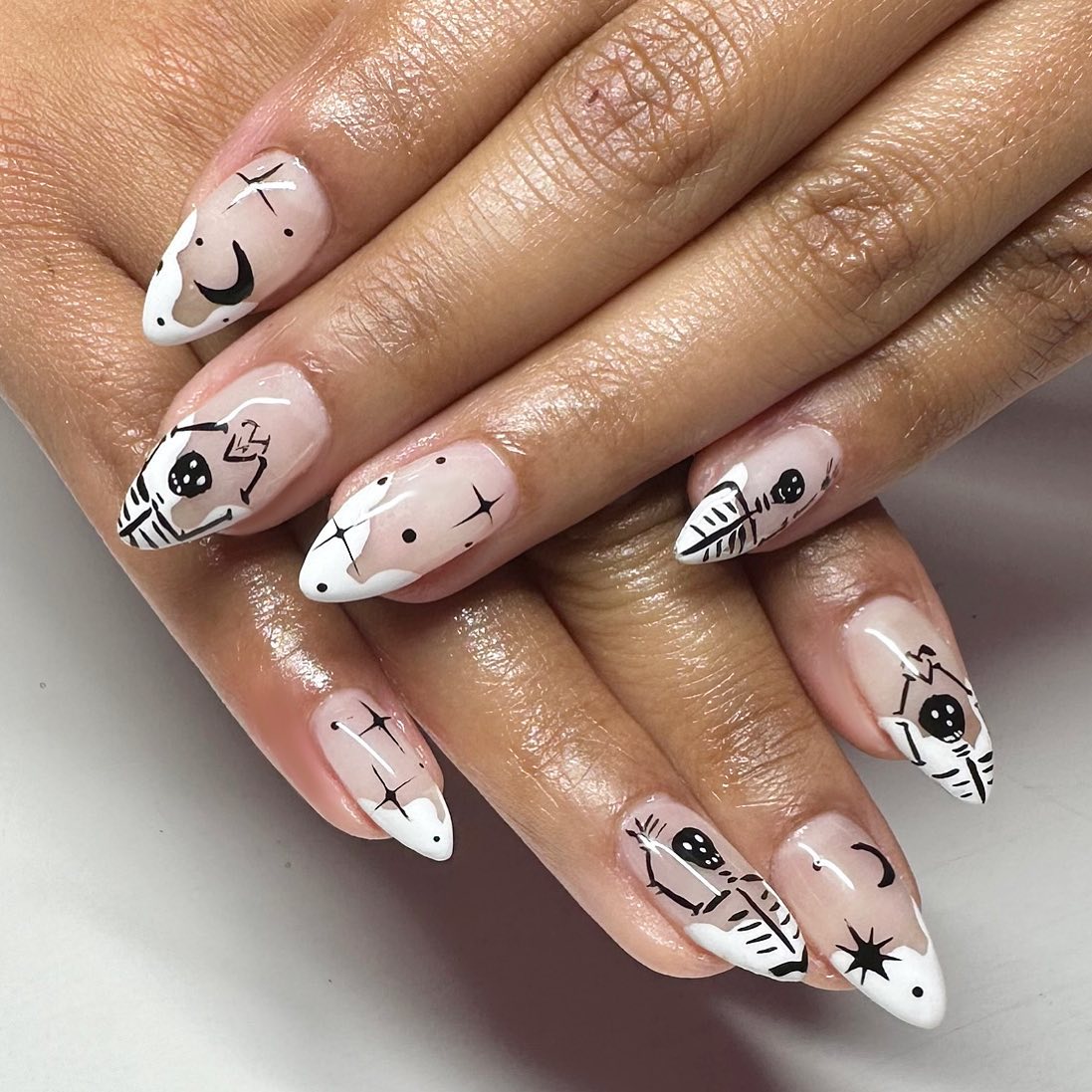 Another example of simple natural nails with transparent base, black or white french tips and different halloween characters like skeletons, bats and pumpkins