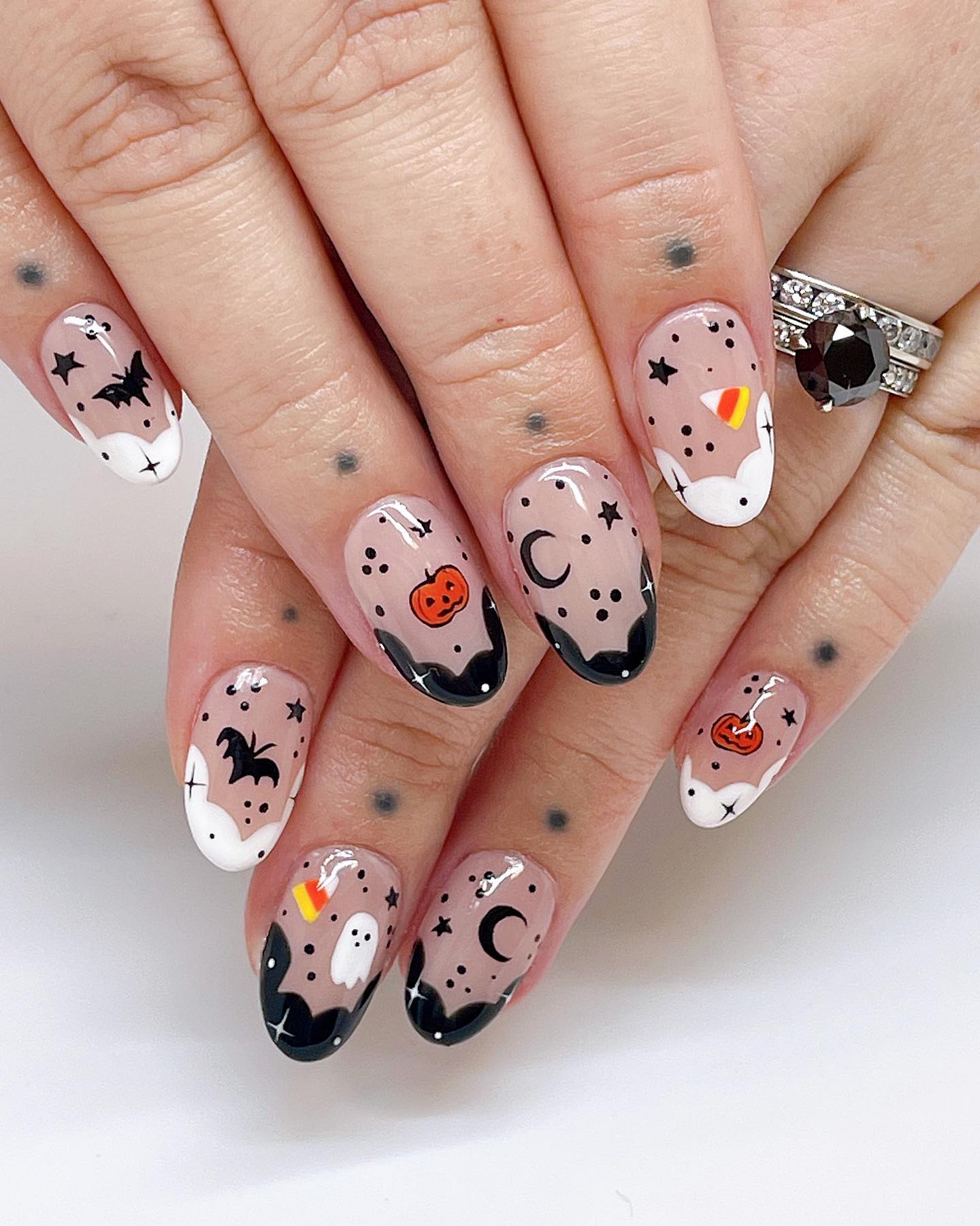 Simple natural nails with transparent base, black or white french tips and different halloween characters like skeletons, bats and pumpkins