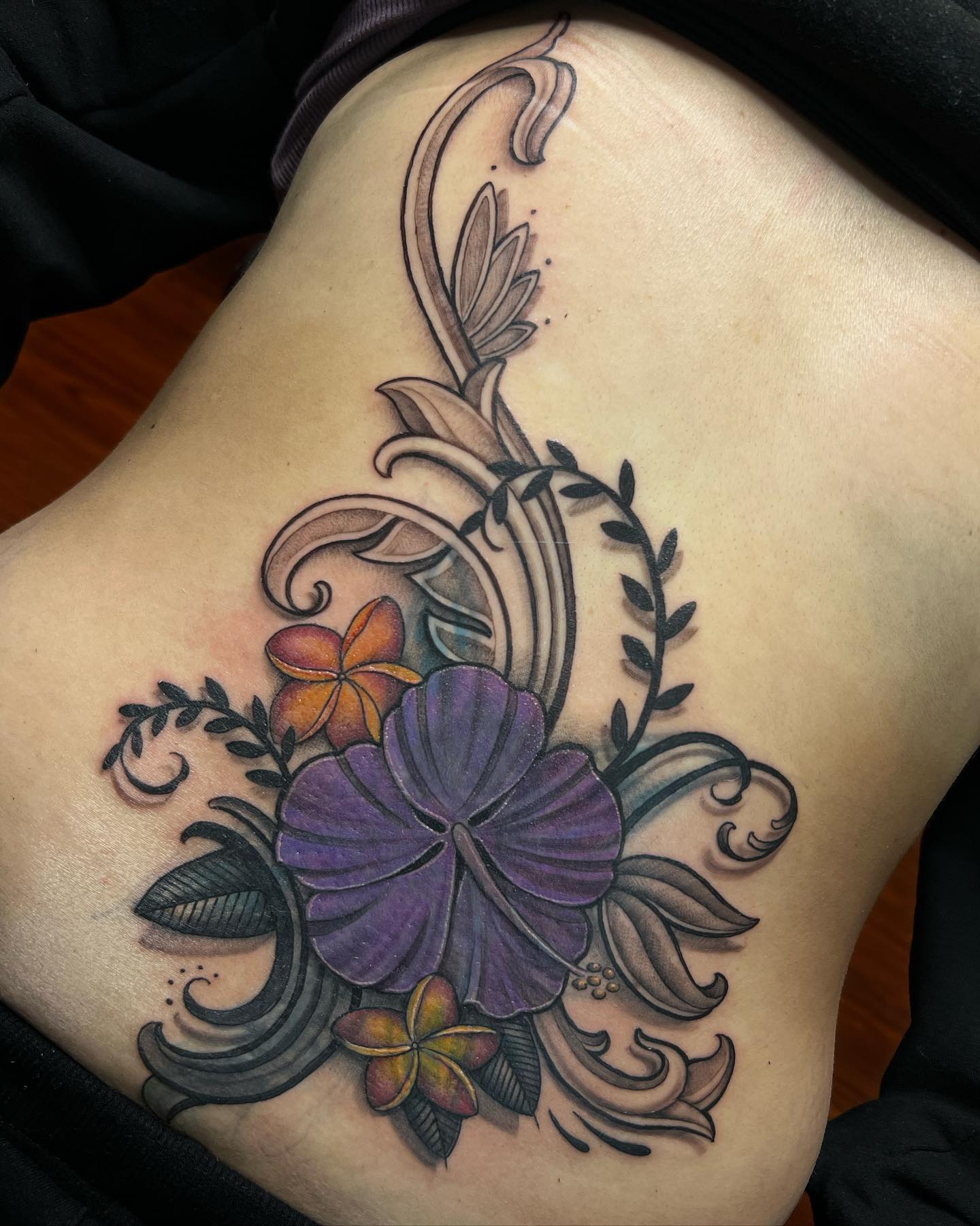 hawaiian flowers on lower back tattoo