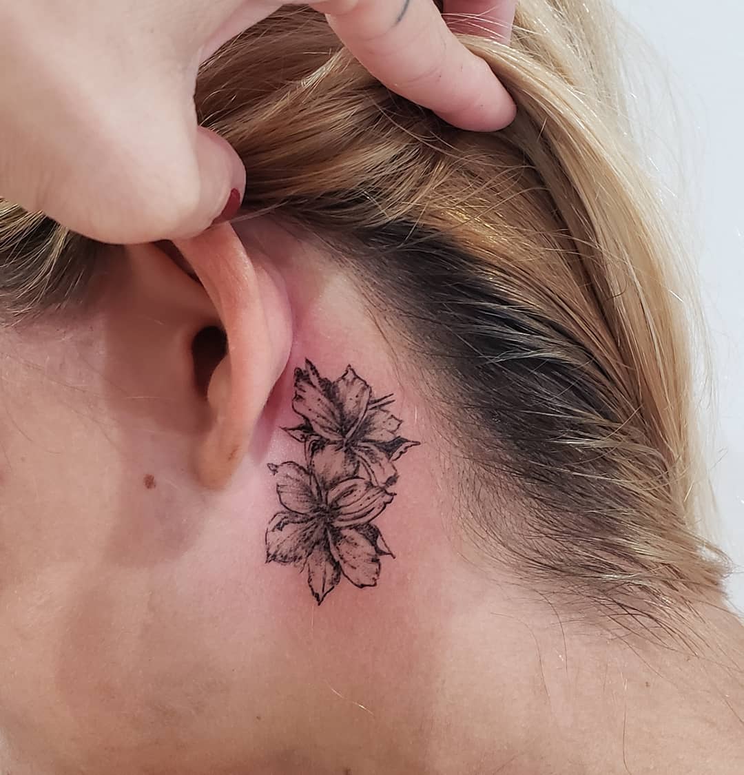 hawajski prosty tatuaż kwiatowy za uchem