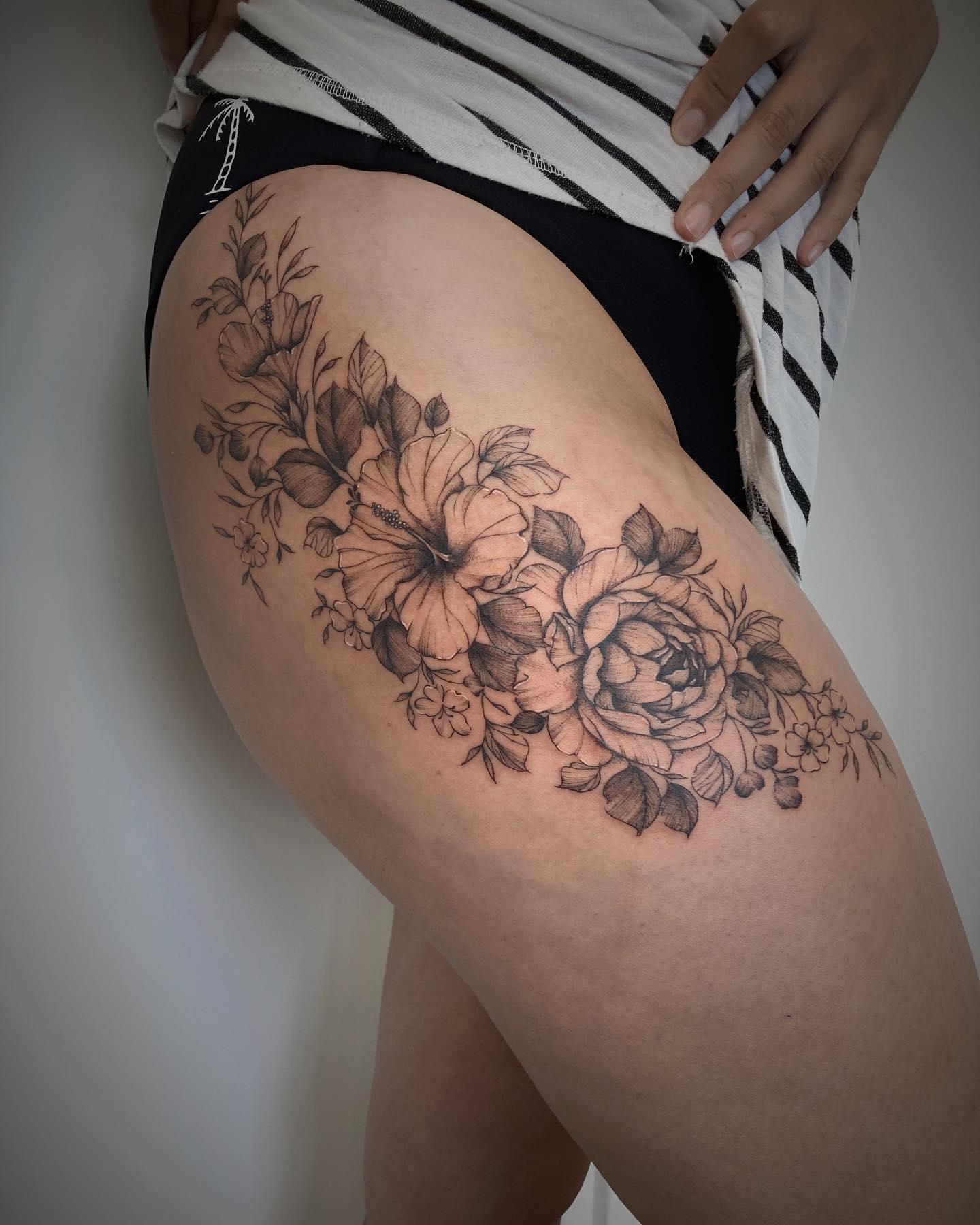 Hawajski tatuaż na udzie z kwiatami