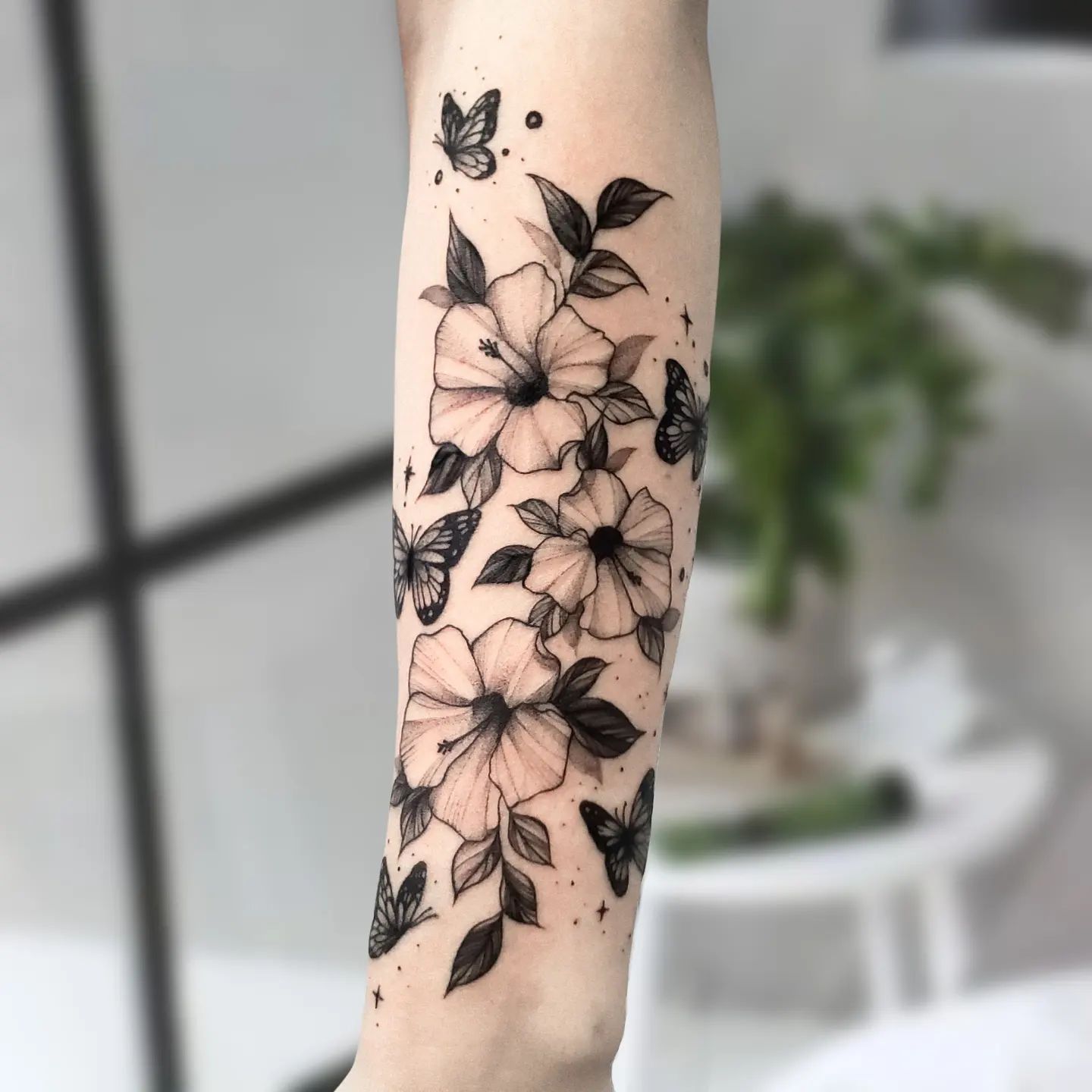 Черно-серая татуировка цветов в гавайском стиле на руке