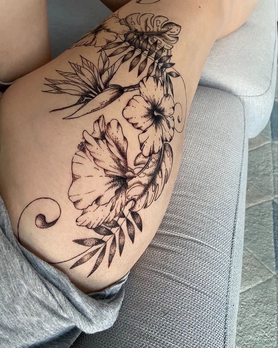 Контурная татуировка цветов в гавайском стиле на бедре