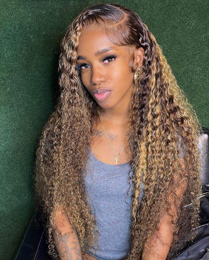 Black woman with honey blonde highlights on long brown curls