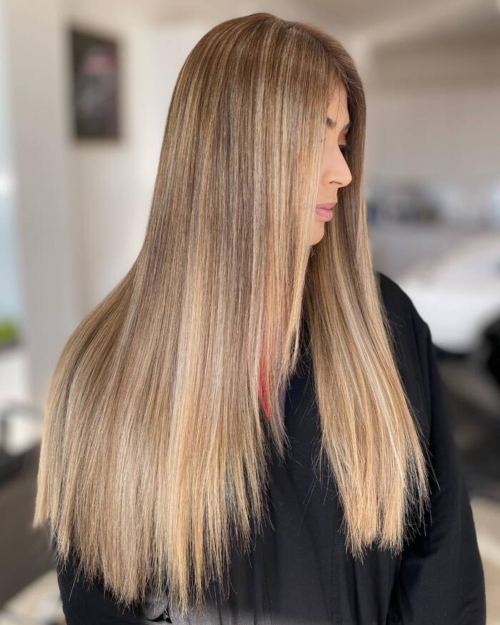 Woman with light honey blonde on straight layered hair 