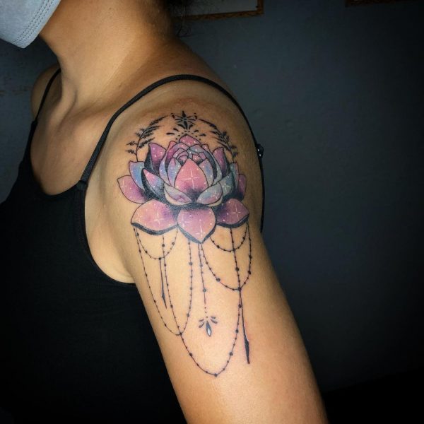 Fioletowy tatuaż lotosu na ramieniu