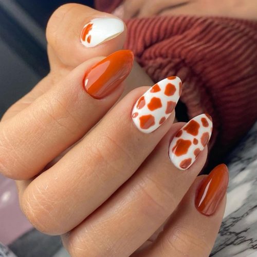 Weiße und orangefarbene Nägel
