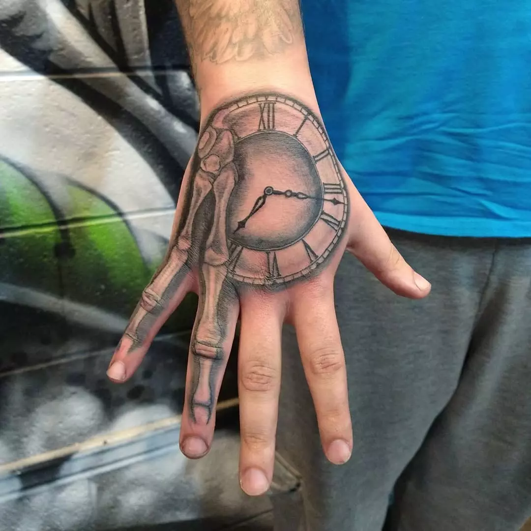 A Close-up Photo of Skeleton Fingers and Clock Hand Tattoo