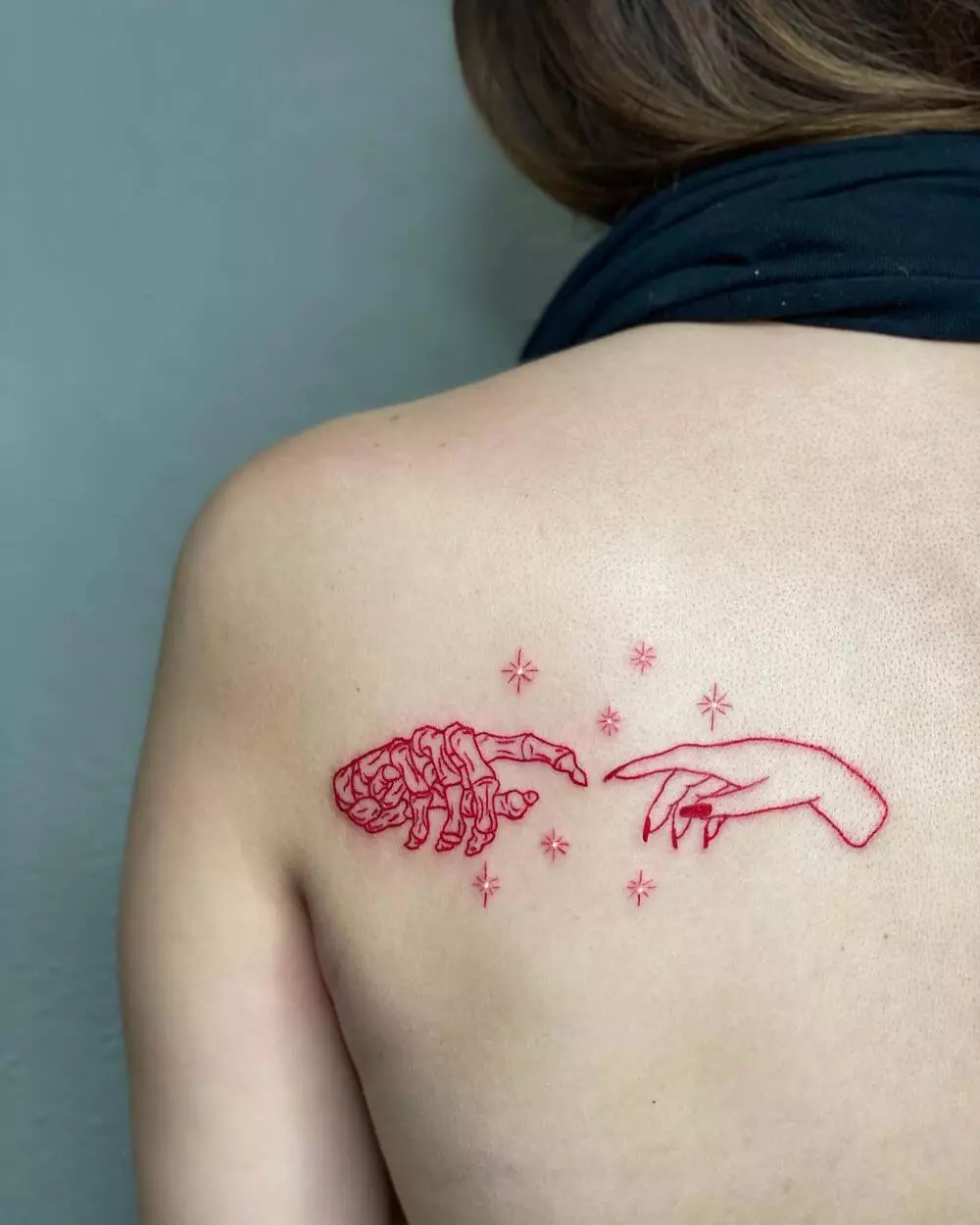 A Close-up Image of Red Ink Skeleton and Human Hands Tattoo