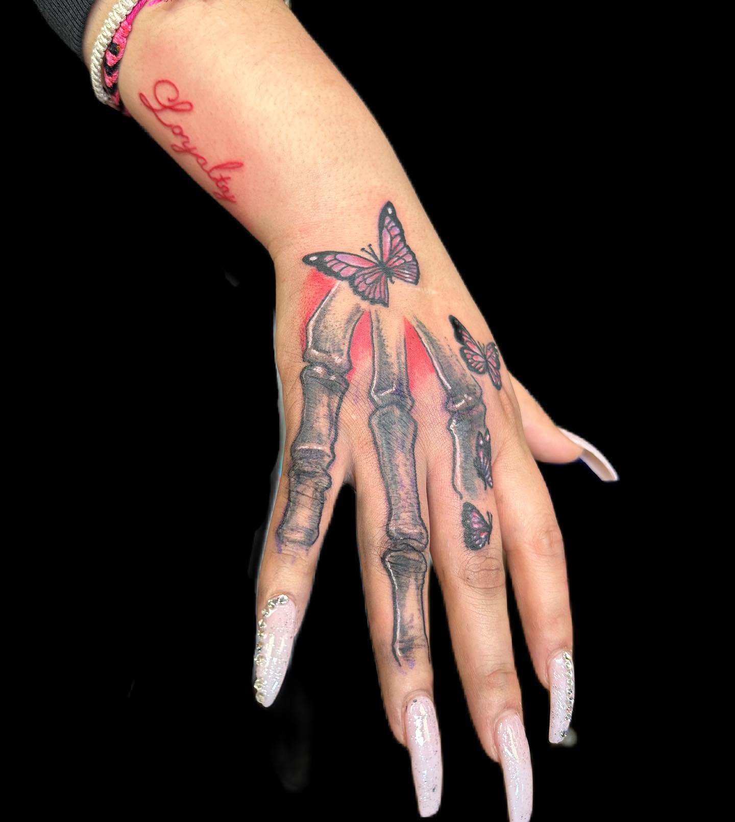 Skeleton hand with butterfly tattoo