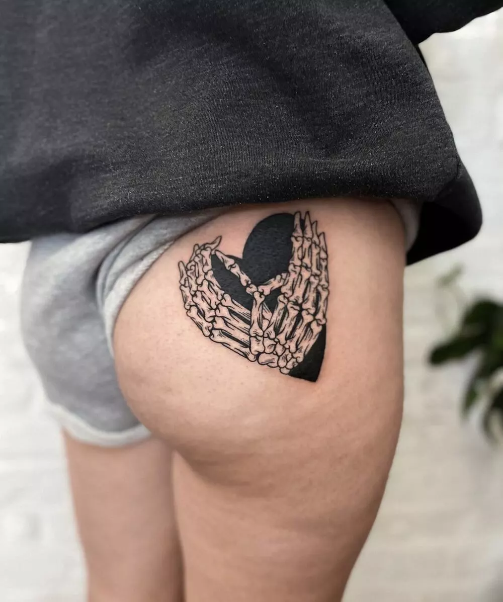 A Close-up Image of Skeleton Hand Heart Tattoo On the Buttock