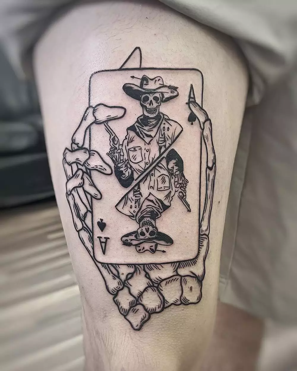 A Close-up Image of Skeleton Hand Holding Card Fine Line Tattoo