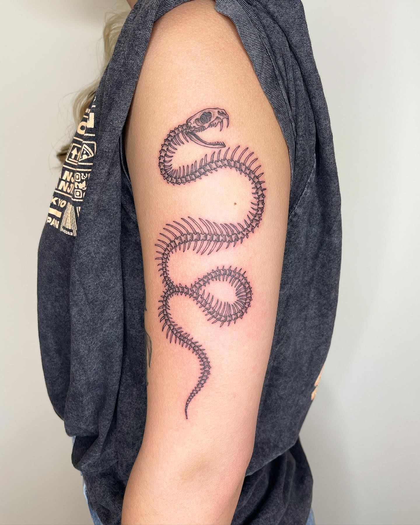 Nahaufnahme des realistischen Schlangen-Skelett-Arm-Tattoos
