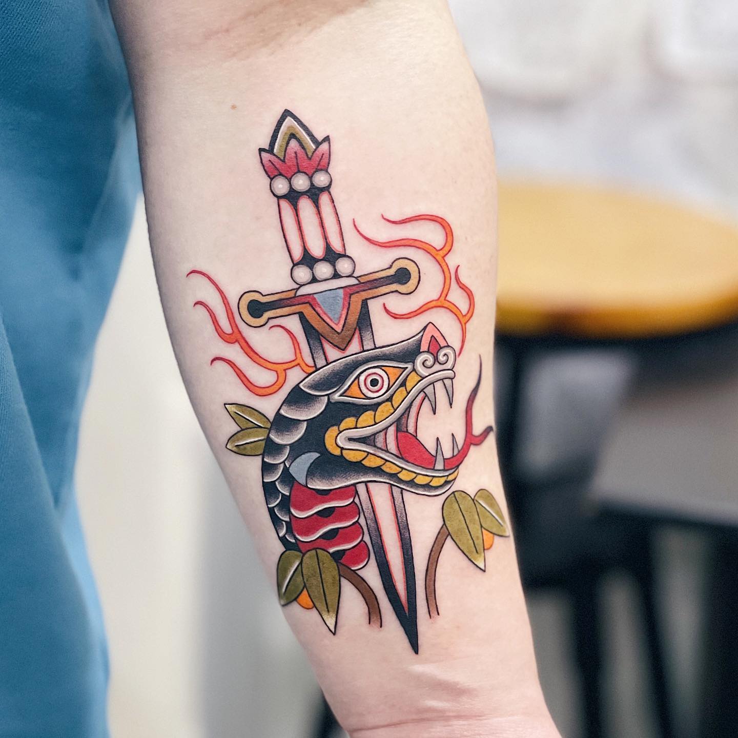 Nahaufnahme des traditionellen Schlangenkopf- und Dolch-Tattoos