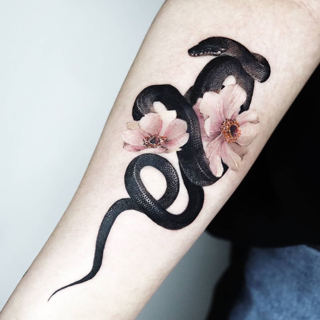 Nahaufnahme des schwarzen Schlangen- und Blumen-Tattoos