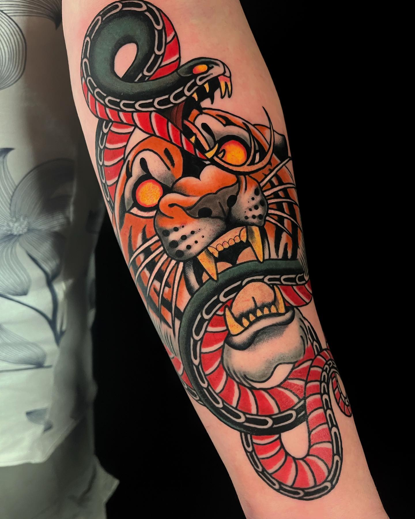 Nahaufnahme des traditionellen Armschlangen- und Tiger-Tattoos