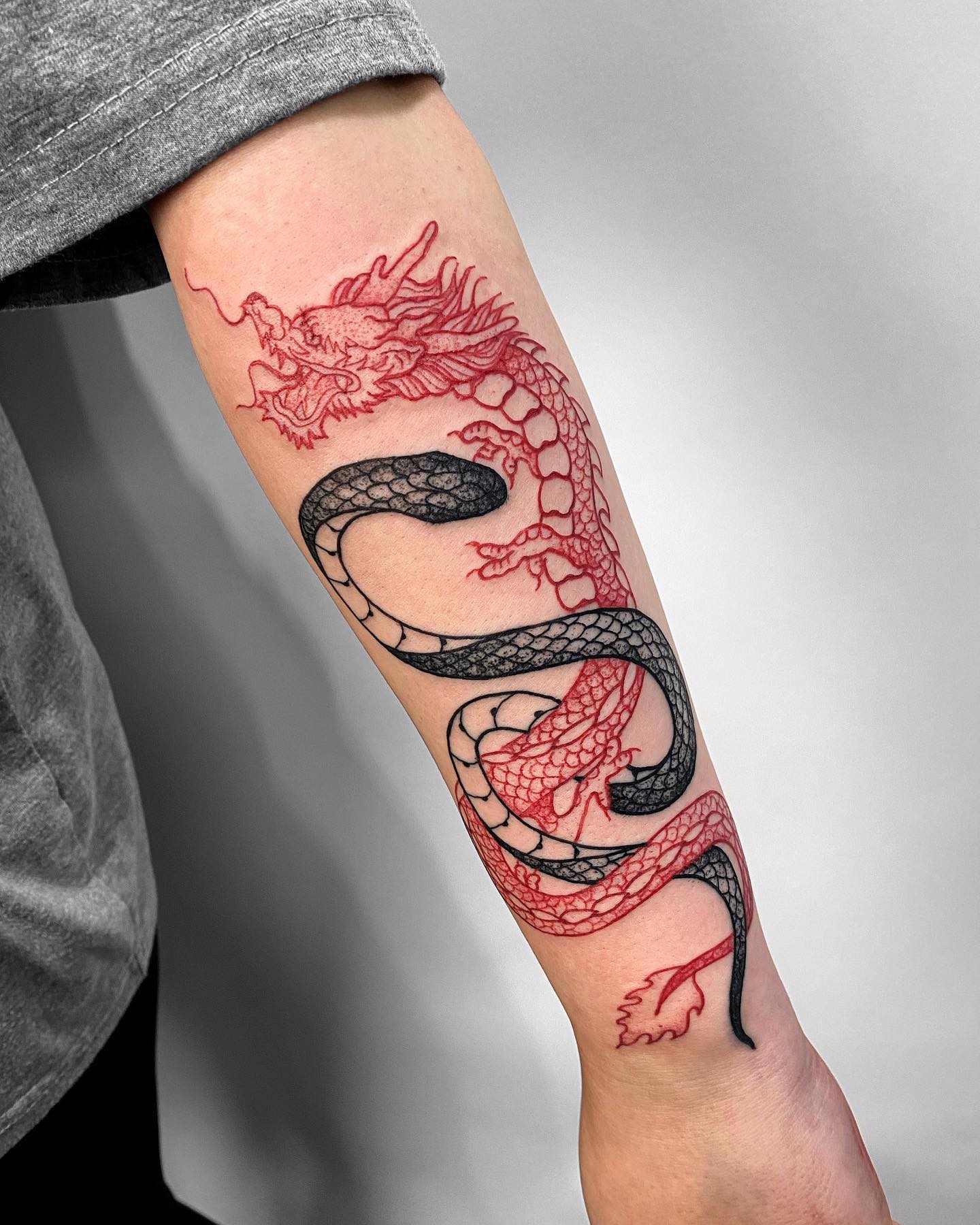 Nahaufnahme des Schlangen- und Drachenarm-Tattoos