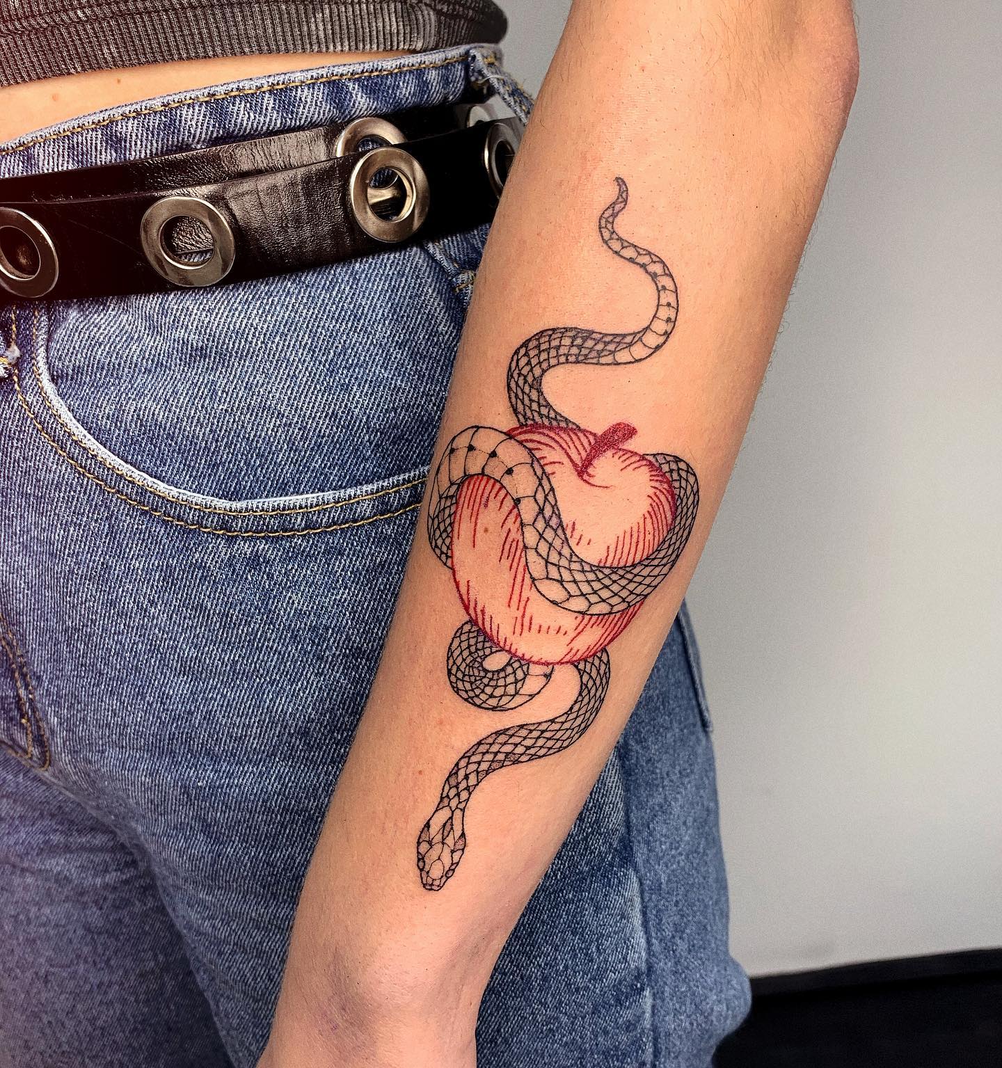 Nahaufnahme des Schlangen- und Apfel-Tattoos