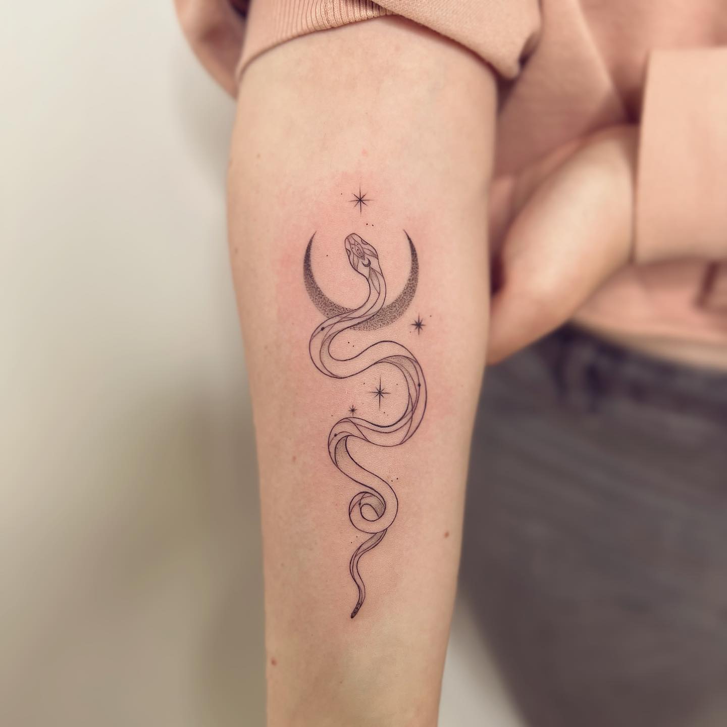 Nahaufnahme des Fine Line Snake Tattoo auf dem Arm