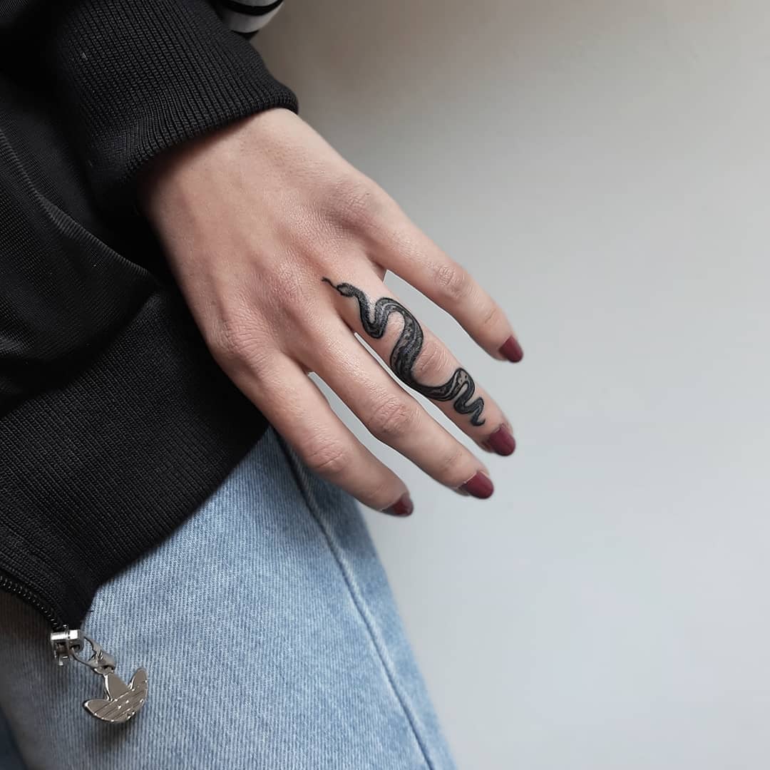 Nahaufnahme des realistischen kleinen Schlangen-Tattoos am Finger