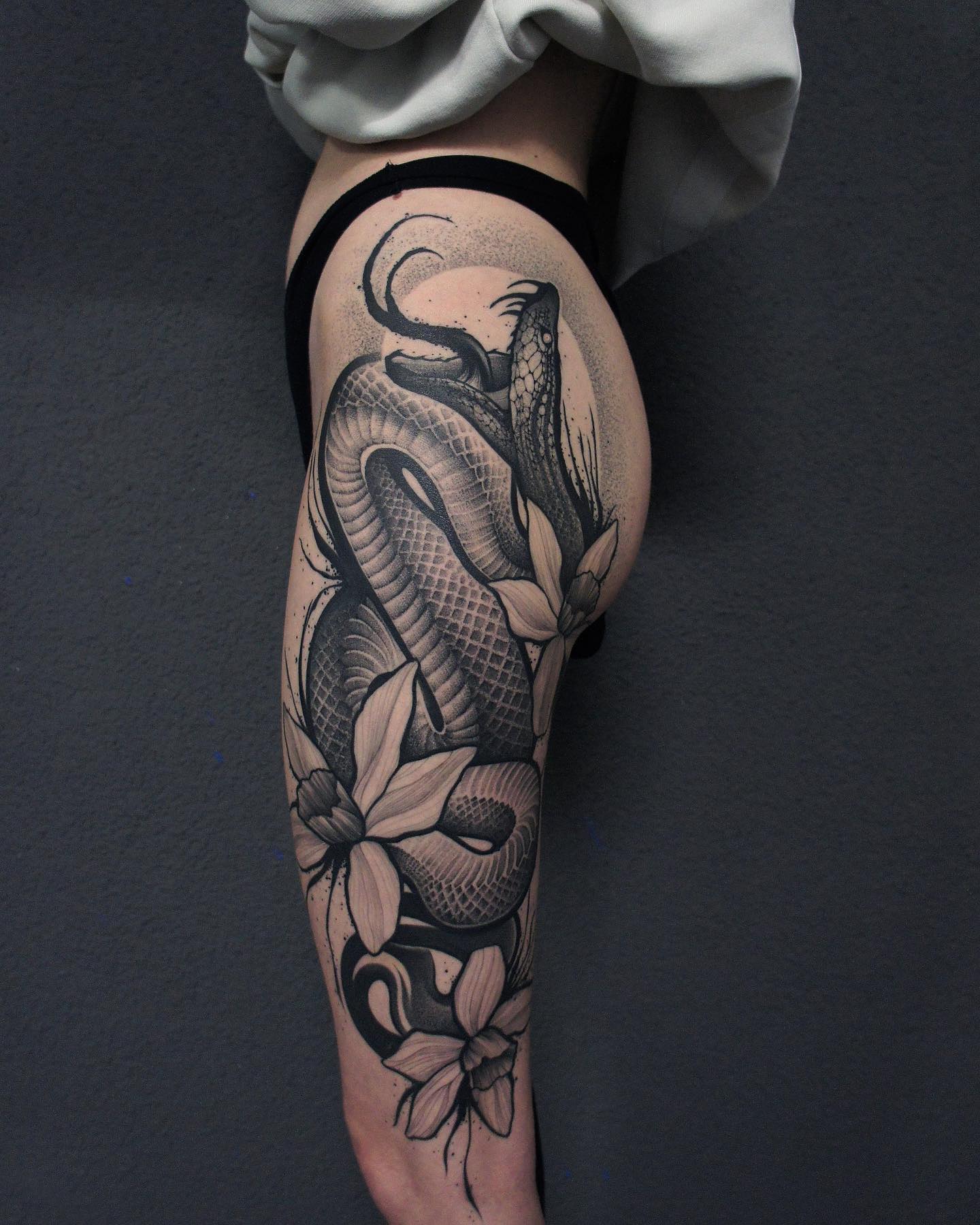 Nahaufnahme des realistischen Klapperschlangen-Oberschenkel-Tattoos