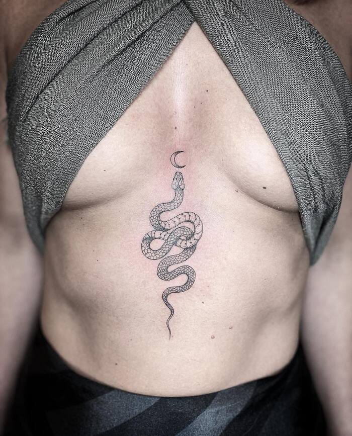 Маленькая татуировка змеи под грудью