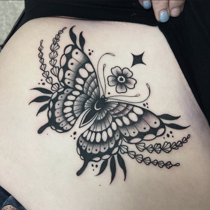 Женская татуировка бабочки под грудью