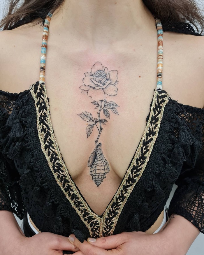 Женская татуировка розы на груди