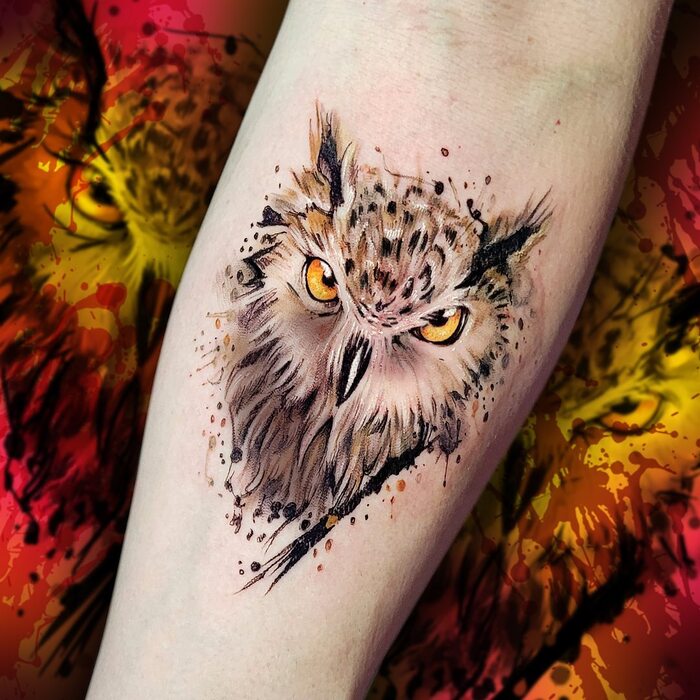 Watercolor tattoo of black, brown and gray owl with yellow eyes