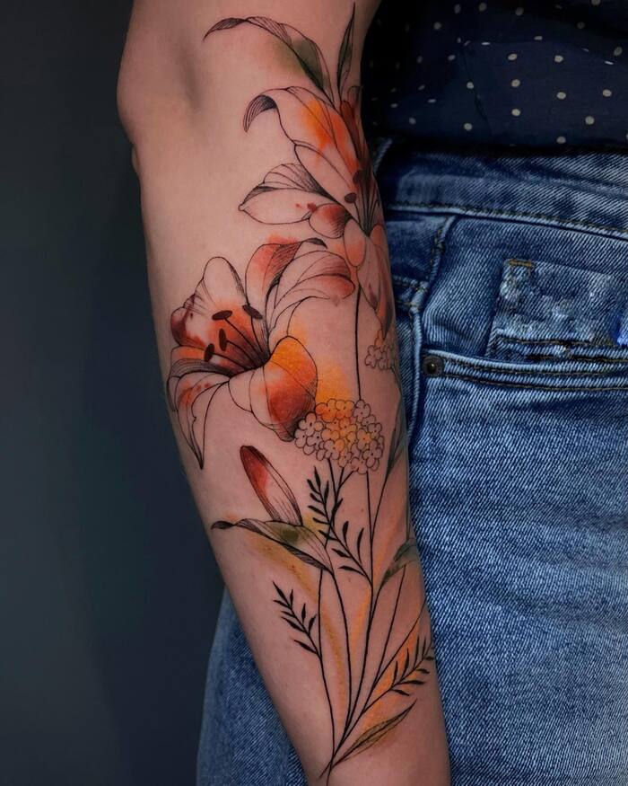 Watercolor tattoo of lily blossom in black, brown and orange main colors