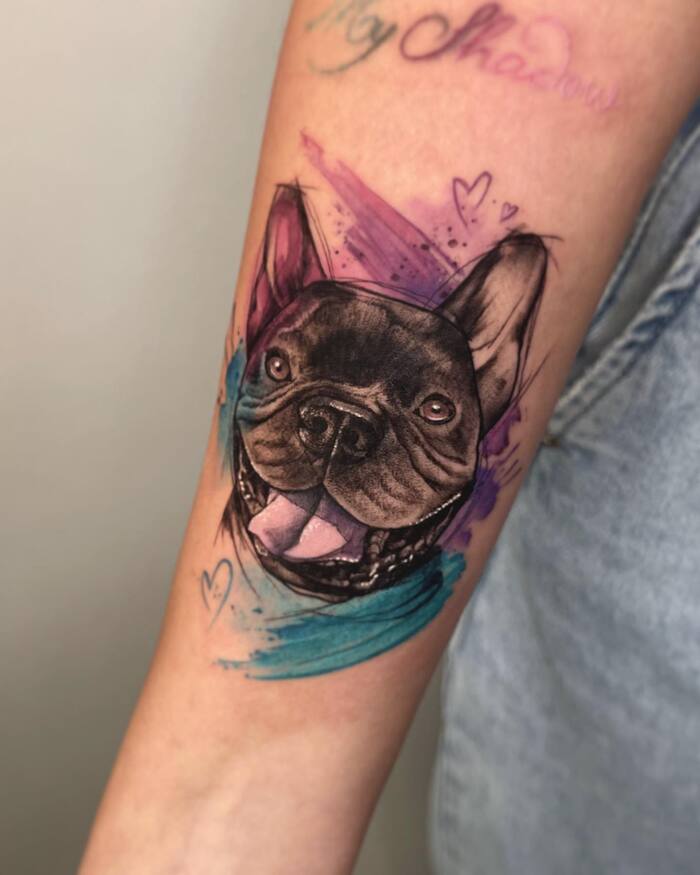 Tattoo of black ink dog surrounded by watercolor brushstrokes