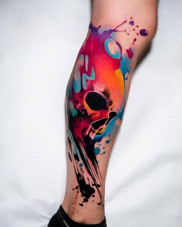 Watercolor tattoo of skull with multi color splashes