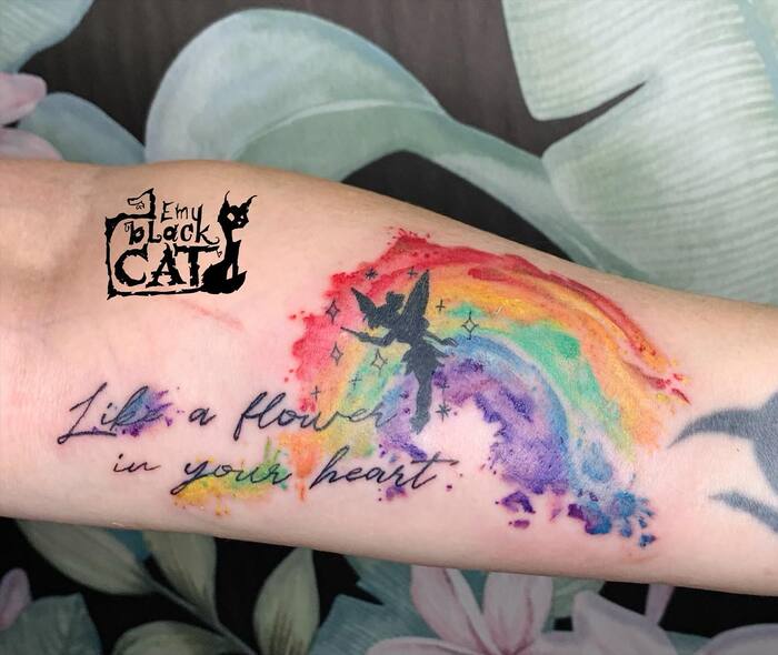 Watercolor tattoo of rainbow with fairy silhouette and meaningful quote