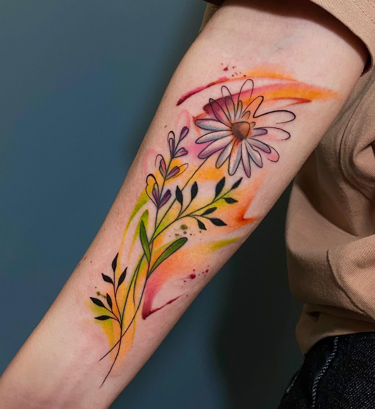 Akwarelowy tatuaż przedstawiający kwiat stokrotki w jesiennych kolorach