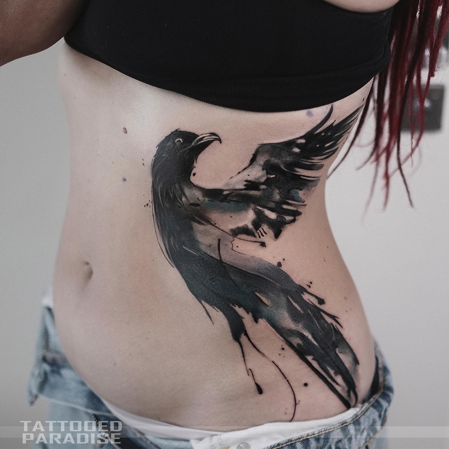 Akwarelowy tatuaż przedstawiający kruka nordyckiego wykonany czarno-białymi tuszami