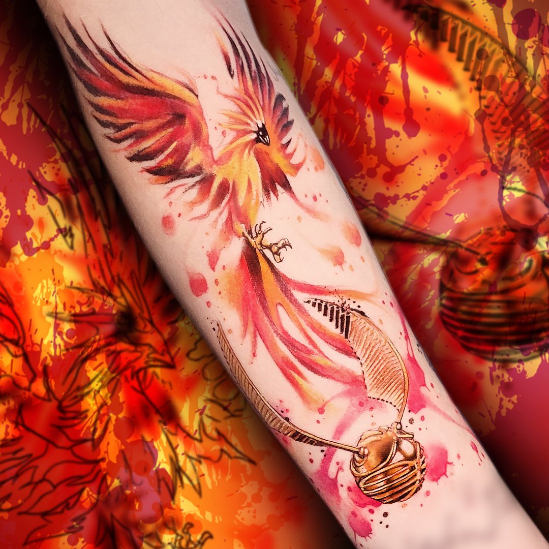 Akwarelowy tatuaż z feniksem wykonany tuszami w kolorze czerwonym, pomarańczowym i żółtym