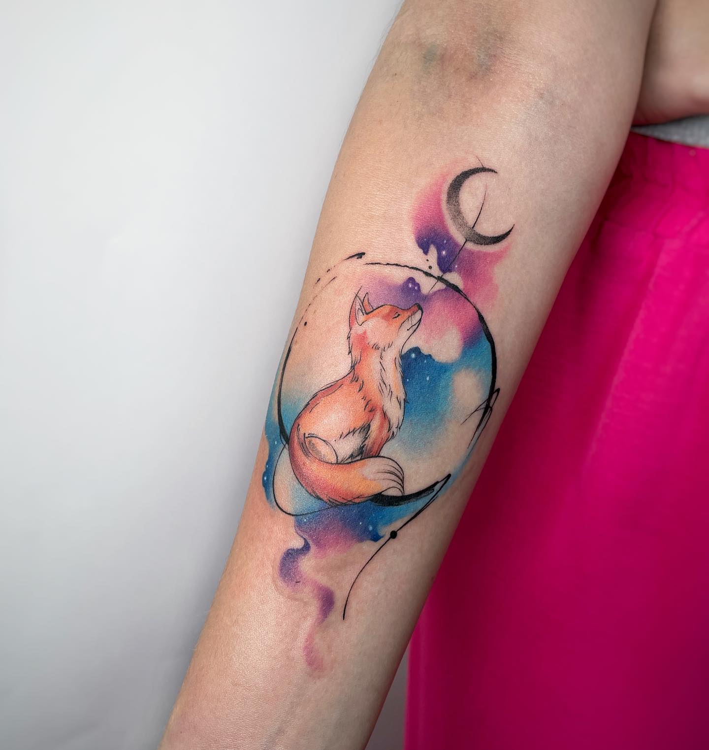 Akwarelowy tatuaż przedstawiający małego lisa obserwującego księżyc