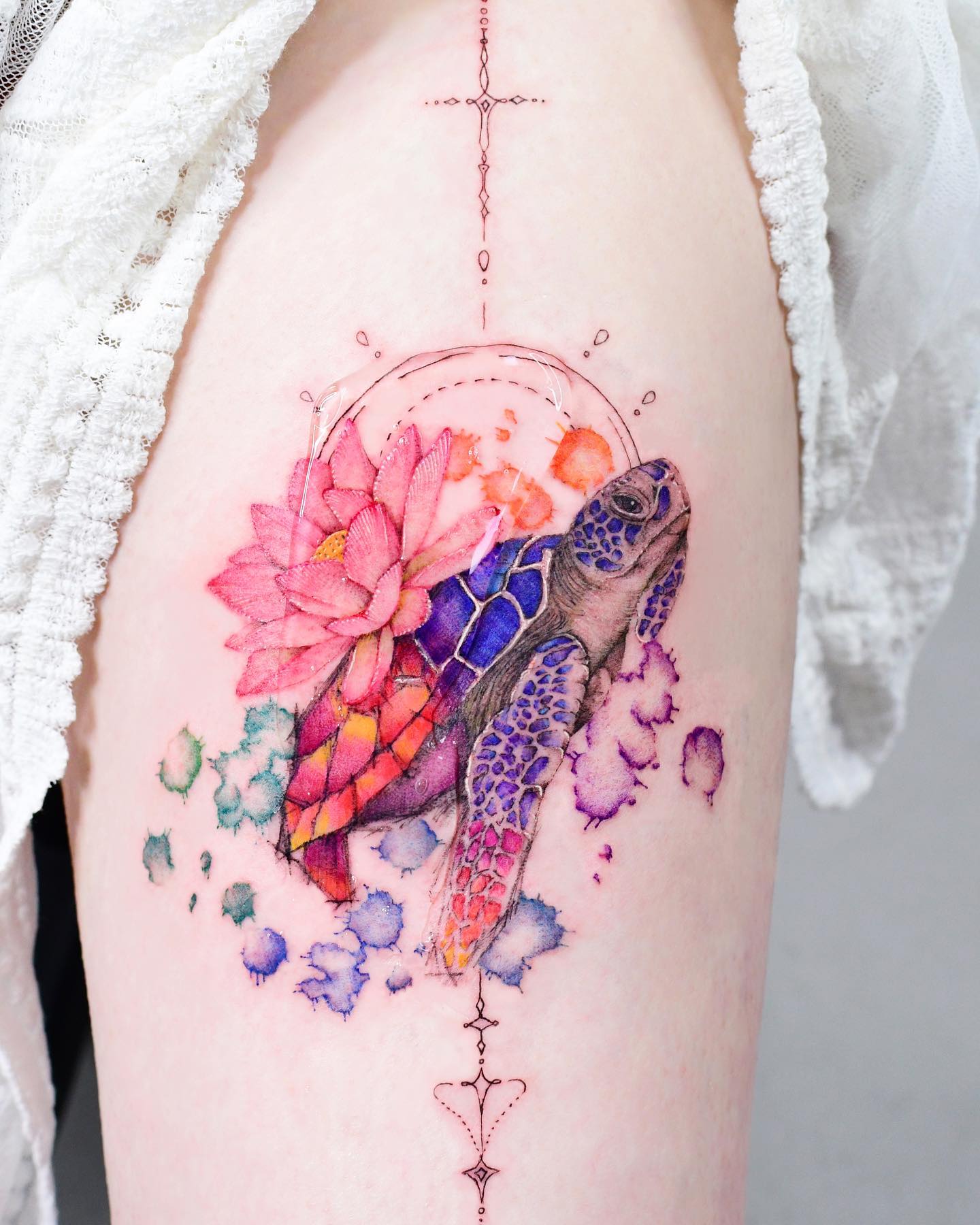 Akwarela tatuaż żółwia w jasnych kolorach niebieskim, czerwonym, różowym, fioletowym i zielonym