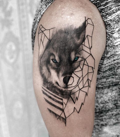tatuaż na ramieniu z geometrią wilka