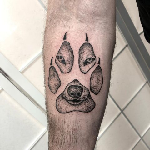 Tattoo mit Wolfspfotenabdruck auf der Hand