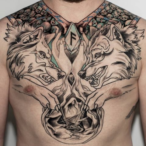 Dwa walczące wilki. Tatuaż na piersi